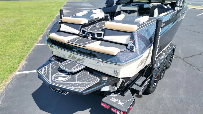 Slide: The Image of 2025 Tigé Ultré 23ZX boat, rear view, parked on pavement, showcasing sleek design and features. - 14