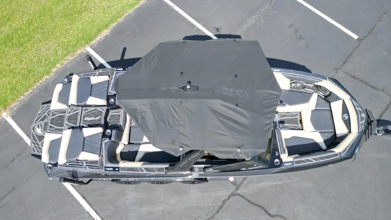 Slide: The Image of 2025 Tigé Ultré 23ZX boat with black canopy, aerial view in parking lot. - 5