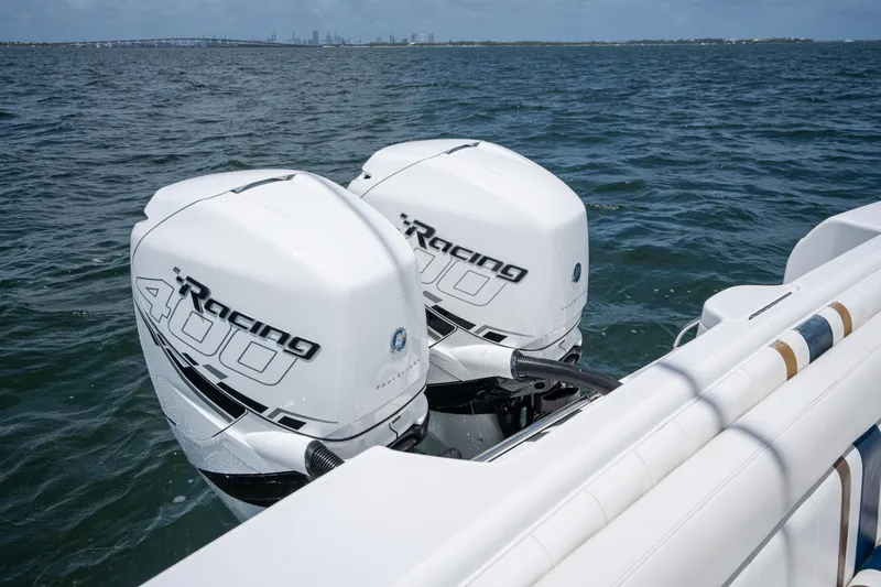 Slide: The Image of Twin Racing 400 outboard motors on a 1999 Intrepid 35 boat, cruising on open water. - 11