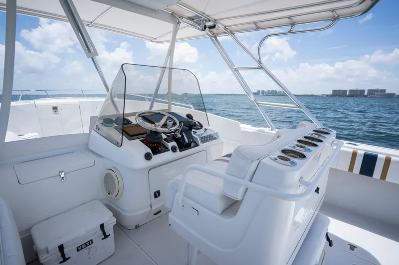 Slide: The Image of 1999 Intrepid 35 boat interior with steering console, ocean view, and clear sky. - 16