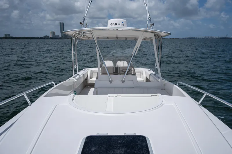 Slide: The Image of 1999 Intrepid 35 boat on water, featuring Garmin equipment, city skyline in background. - 20