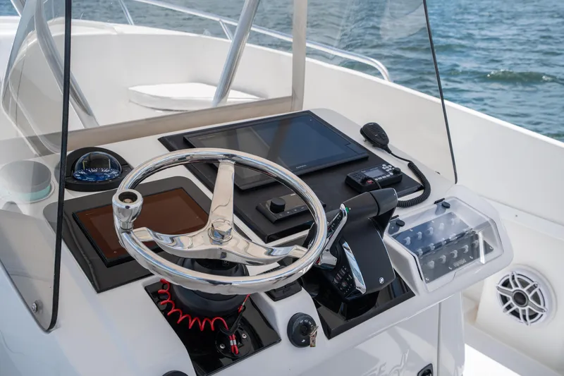 Slide: The Image of Control panel of a 1999 Intrepid 35 boat with steering wheel and navigation equipment. - 22