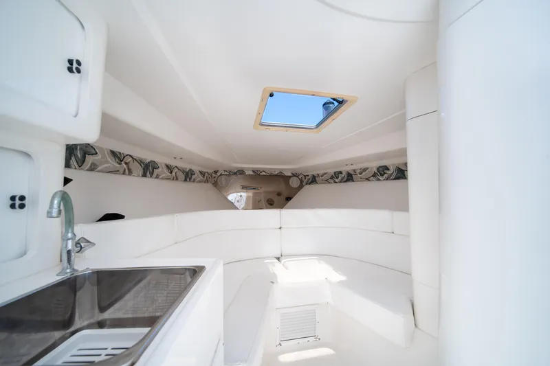 Slide: The Image of Interior of a 1999 Intrepid 35 boat with white seating and a skylight. - 23