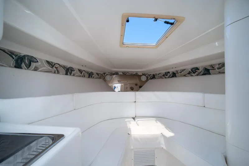 Slide: The Image of 1999 Intrepid 35 boat interior with white seating and skylight. - 24