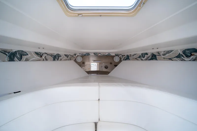 Slide: The Image of Interior cabin of a 1999 Intrepid 35 boat with white seating and patterned wall accents. - 26