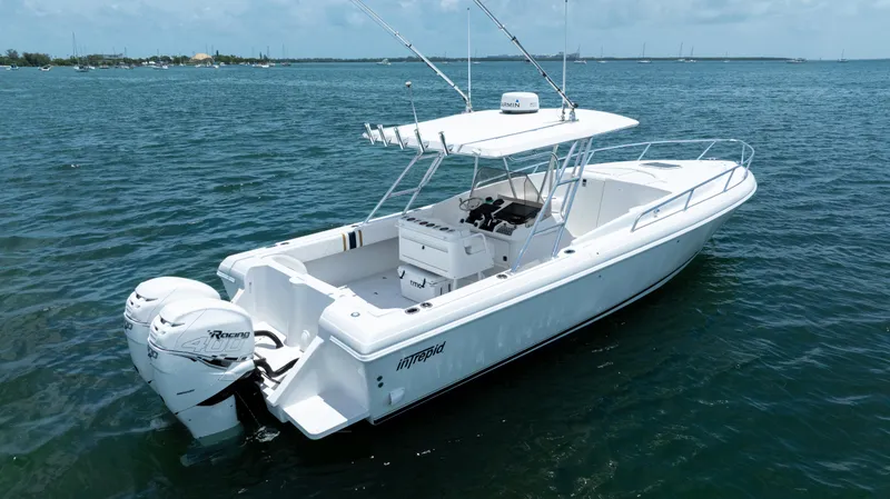 Slide: The Image of 1999 Intrepid 35 boat on calm water, featuring twin outboard engines. - 8