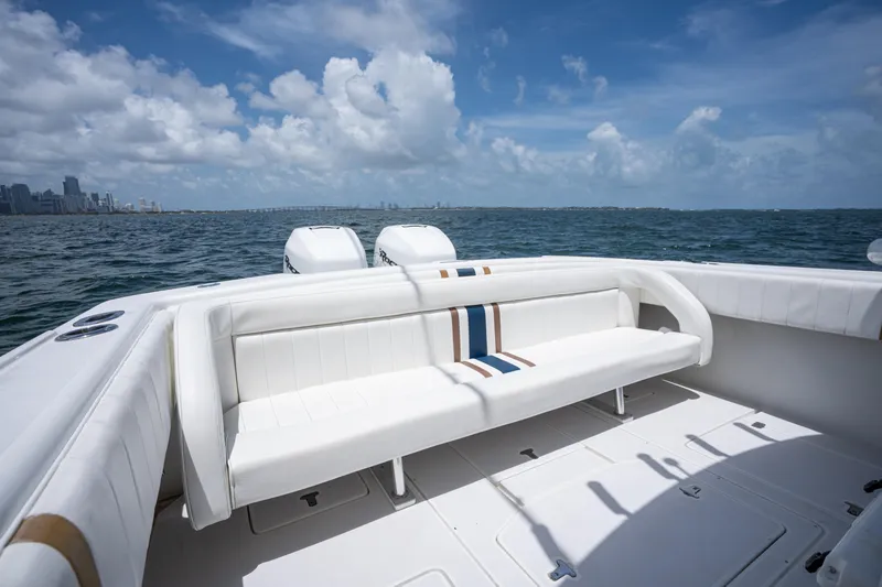 Slide: The Image of 1999 Intrepid 35 boat interior with white seating, ocean view, and city skyline in the background. - 9