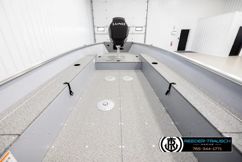 Slide: The Image of 2026 Lund 1600 Fury Tiller boat interior in a showroom, featuring spacious seating and storage. - 14