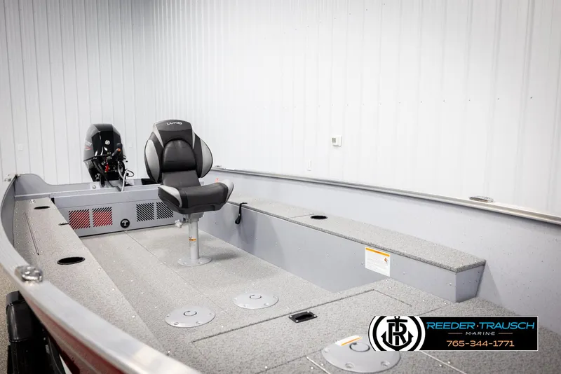 Slide: The Image of 2026 Lund 1600 Fury Tiller boat interior with seating and motor, displayed indoors. - 27