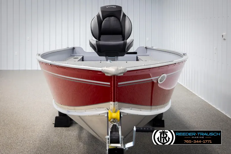 Slide: The Image of 2026 Lund 1600 Fury Tiller boat in showroom, red exterior, Reeder-Trausch Marine logo visible. - 6