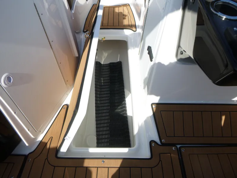 Slide: The Image of 2025 Yamaha Boats 222SD interior storage compartment with teak-style flooring. - 11