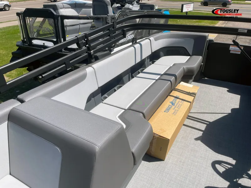Slide: The Image of 2025 Manitou Cruise 20 MAX Bench Twin Tube interior with gray seating and packaging box. - 6
