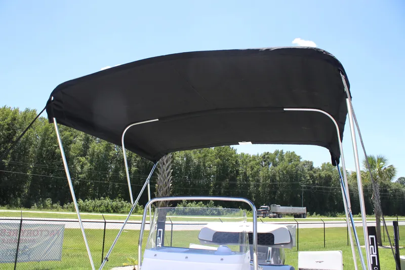 Slide: The Image of 2026 Tidewater 1910 Bay Max boat with black canopy, parked outdoors. - 24