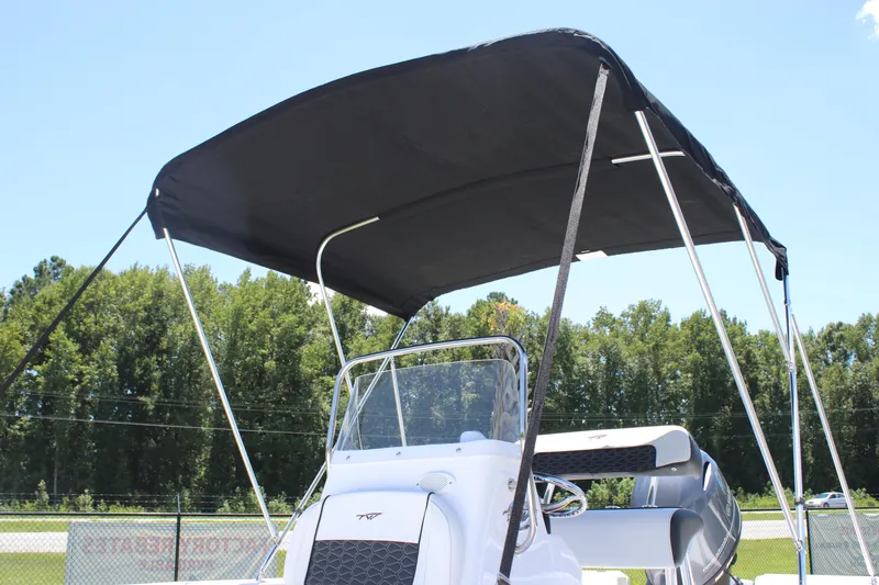 Slide: The Image of 2026 Tidewater 1910 Bay Max boat with canopy, set against a clear sky and trees. - 26