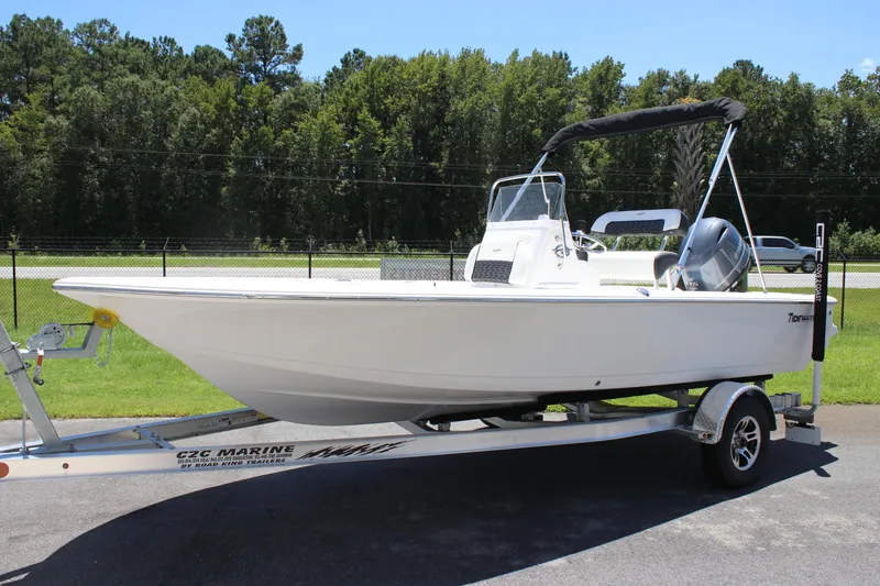 Slide: The Image of 2026 Tidewater 1910 Bay Max boat on trailer, parked outdoors with trees in background. - 3