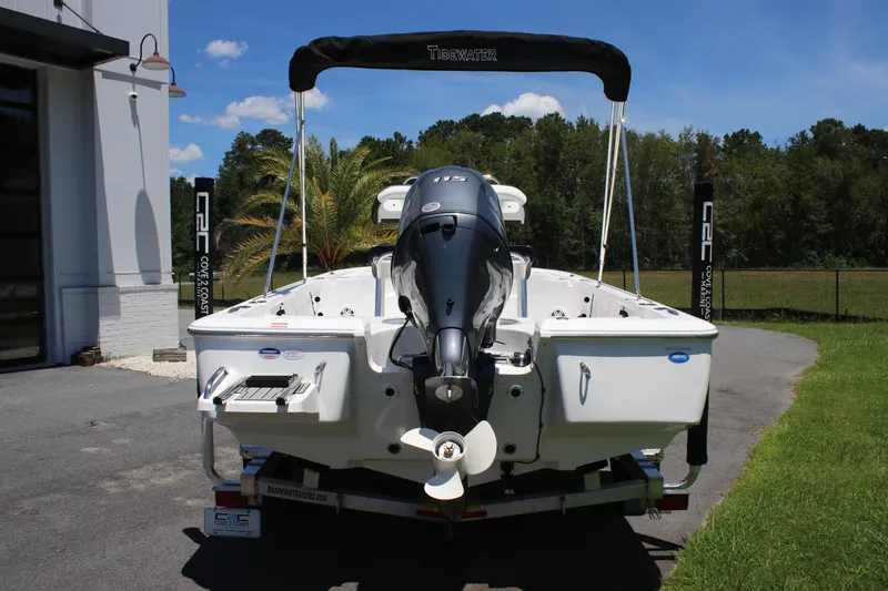 Slide: The Image of 2026 Tidewater 1910 Bay Max boat with outboard motor, parked outdoors on a sunny day. - 6