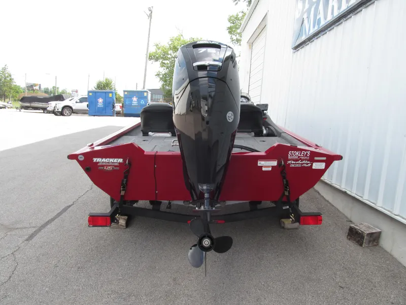 Slide: The Image of 2023 Tracker Pro Team 175 TF boat, red exterior, parked near a building. - 4