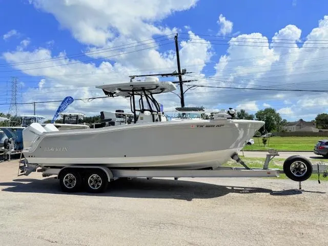 Slide: The Image of 2022 Blackfin 252 CC boat on trailer, featuring dual Mercury outboard engines, under a sunny sky. - 1
