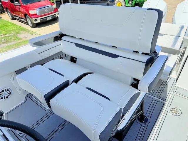 Slide: The Image of 2022 Blackfin 252 CC interior with wooden seat, fire extinguisher, and control panel. - 14