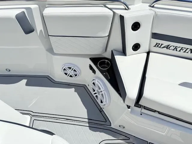 Slide: The Image of 2022 Blackfin 252 CC boat interior with cushioned seating and speaker system. - 23