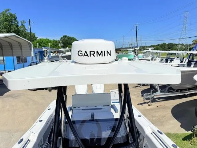 Slide: The Image of 2022 Blackfin 252 CC boat with white seating and trolling motor, parked in a marina. - 26