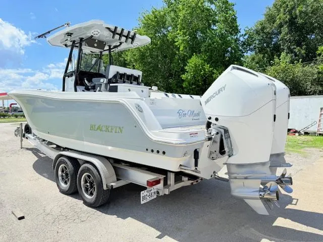 Slide: The Image of 2022 Blackfin 252 CC boat with dual Mercury engines, featuring a sleek design and fishing rod holders. - 4