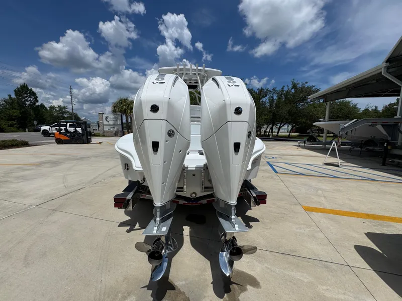 Slide: The Image of 2026 Yellowfin 26 Hybrid boat with dual outboard engines, parked outdoors under a blue sky. - 14