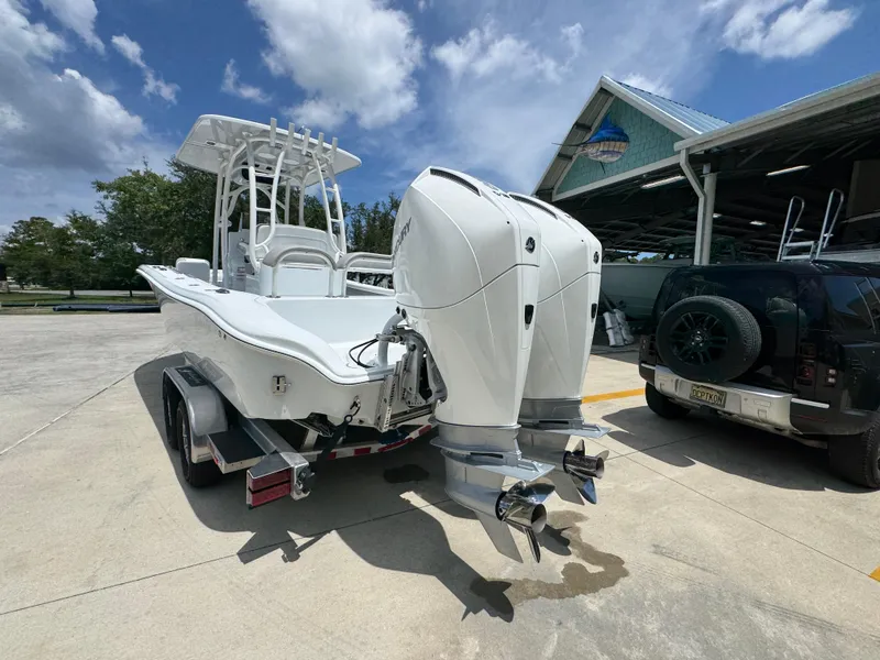 Slide: The Image of 2026 Yellowfin 26 Hybrid boat with dual engines on a trailer, parked outdoors. - 15