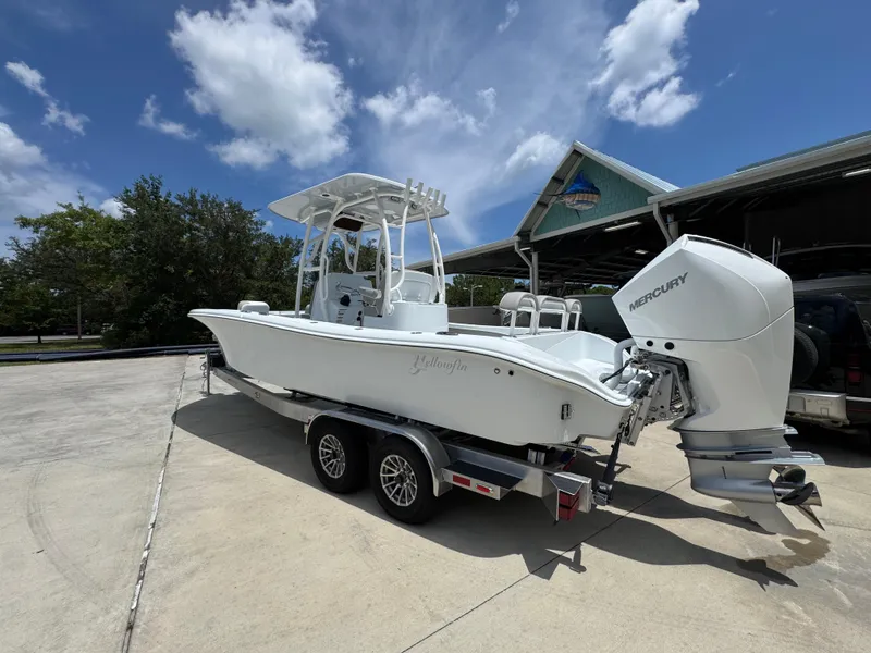 Slide: The Image of 2026 Yellowfin 26 Hybrid boat with Mercury engine on trailer under blue sky. - 16