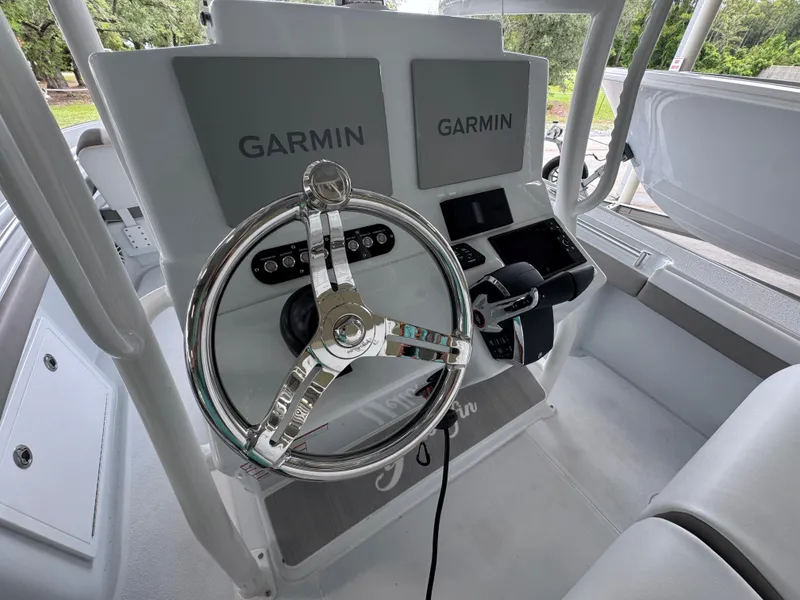 Slide: The Image of 2026 Yellowfin 26 Hybrid boat dashboard with Garmin displays and steering wheel. - 30
