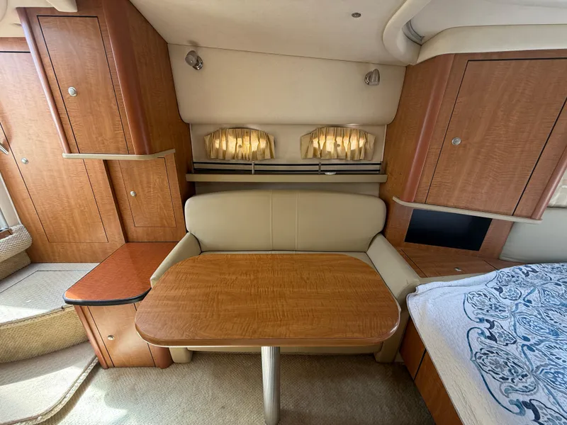 Slide: The Image of 2006 Sea Ray 290 Sundancer cabin interior with wooden table and seating area. - 14