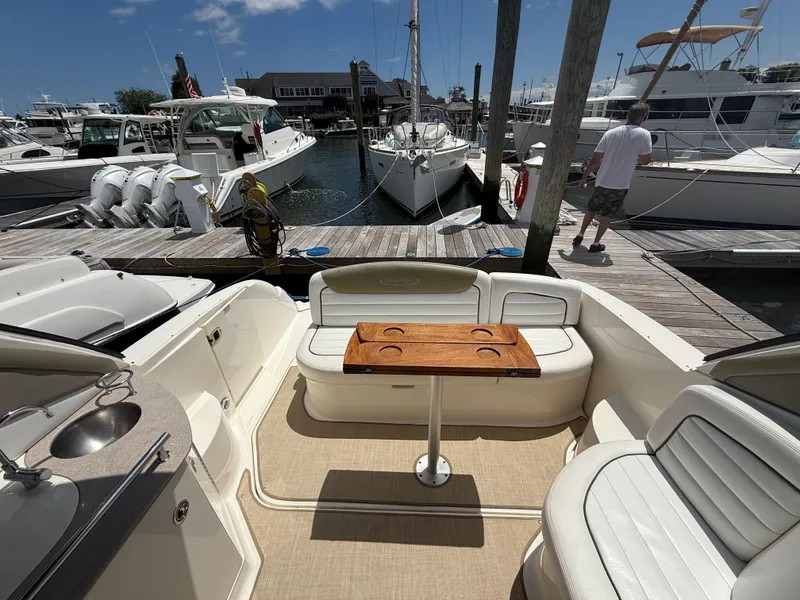 Slide: The Image of 2006 Sea Ray 290 Sundancer interior with seating and table at marina dock. - 3