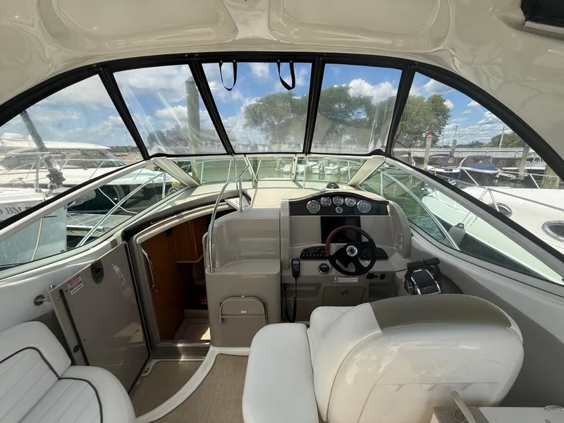 Slide: The Image of 2006 Sea Ray 290 Sundancer cockpit with steering wheel and dashboard, docked at marina. - 7