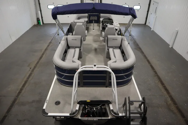 Slide: The Image of 2025 Bentley Pontoons 240 Navigator with spacious seating and canopy in a showroom. - 10