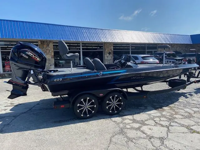 Slide: The Image of 2026 iKon VLX 20 boat with trailer, parked outside a building under a blue sky. - 2