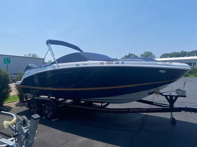 Slide: The Image of 2023 Four Winns HD3 boat on trailer, parked outdoors under clear sky. - 4