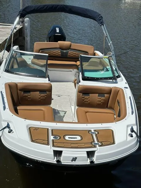 Slide: The Image of 2023 Four Winns HD3 boat with tan seating, docked on calm water. - 6
