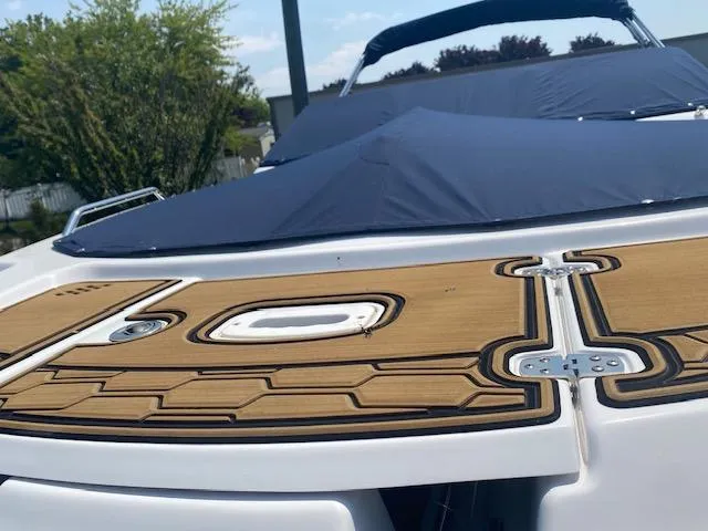 Slide: The Image of 2023 Four Winns HD3 boat with sleek deck design and blue cover. - 7