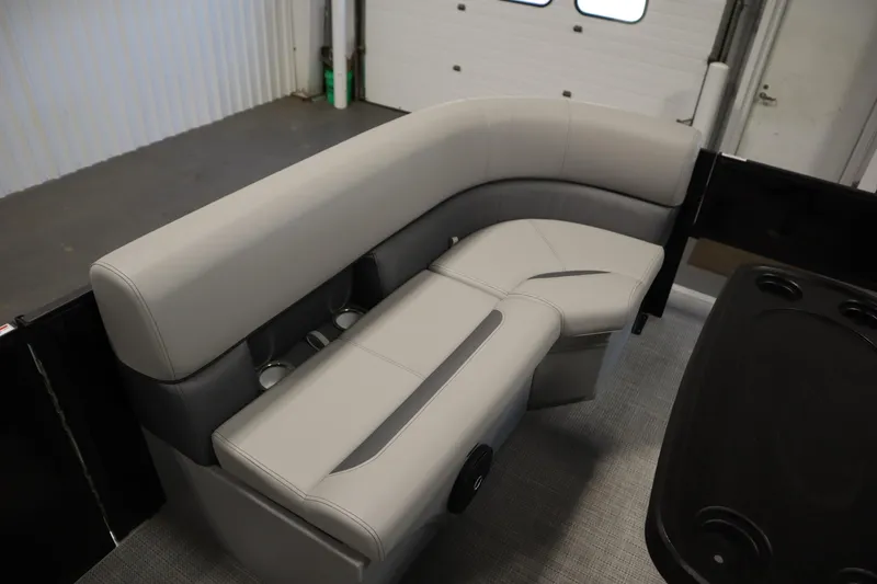 Slide: The Image of 2025 Bentley Pontoons 220 Fish-N-Cruise interior seating with cup holders in a garage setting. - 12
