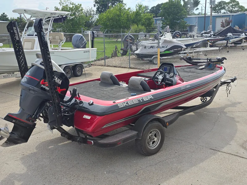 Slide: The Image of 2014 Skeeter ZX 190 boat with Yamaha engine, parked on a trailer in a marina. - 4