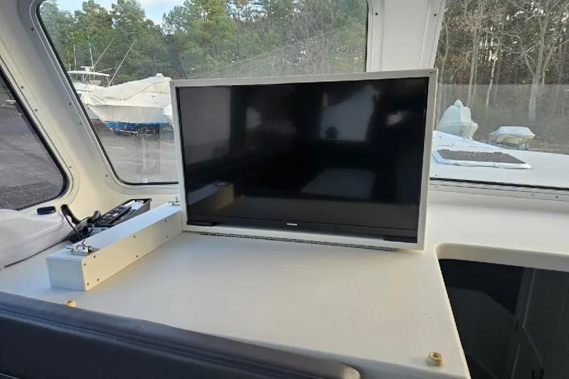 Slide: The Image of Boat interior with a mounted TV, surrounded by windows and outdoor view. - 12