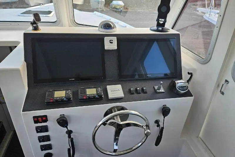 Slide: The Image of Boat cockpit with dual screens, steering wheel, and navigation controls, Flowers Down East 2022 model. - 19
