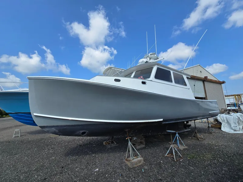 Slide: The Image of A 2022 Flowers Down East boat on stands, under a clear blue sky. - 2
