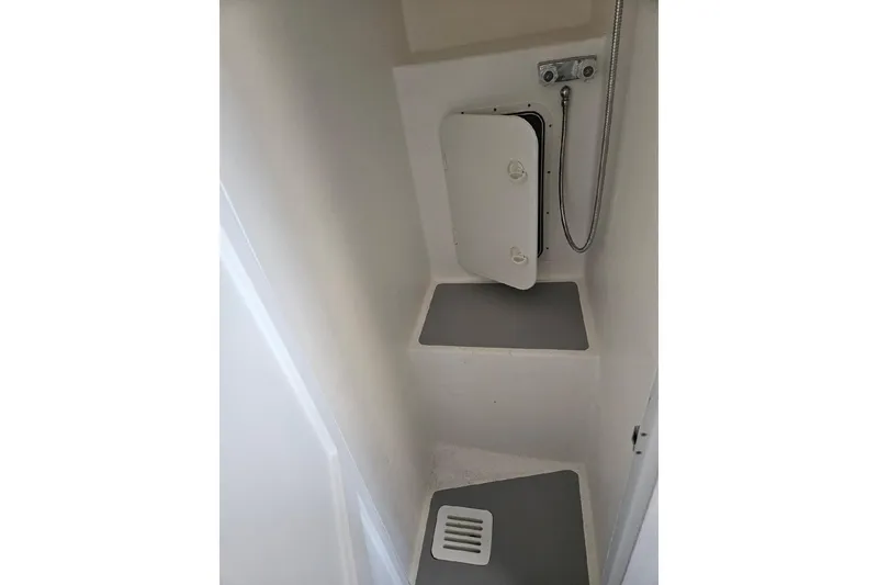 Slide: The Image of Compact shower area in a 2022 Flowers Down East boat, featuring a small hatch and drain. - 21