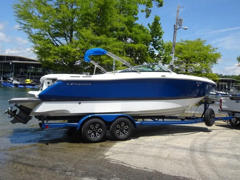 Slide: The Image of 2023 Four Winns H260 boat on trailer by lakeside, ready for launch. - 2
