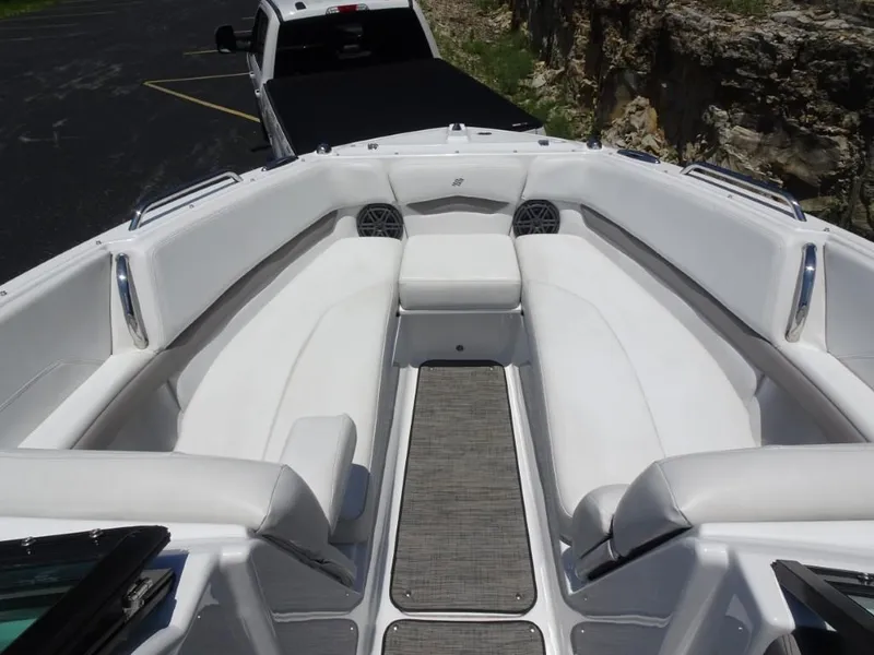 Slide: The Image of 2023 Four Winns H260 boat interior with white seating and gray flooring. - 20