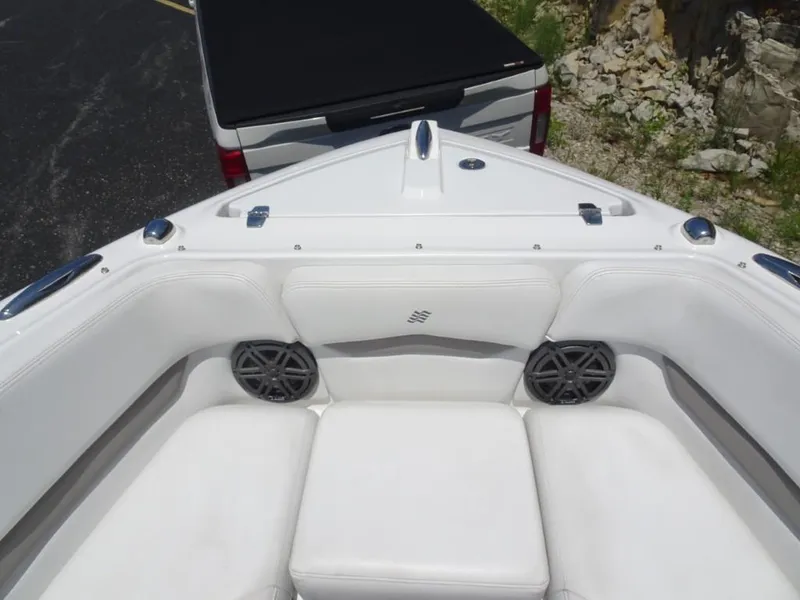 Slide: The Image of 2023 Four Winns H260 boat interior with white seating and speakers. - 21
