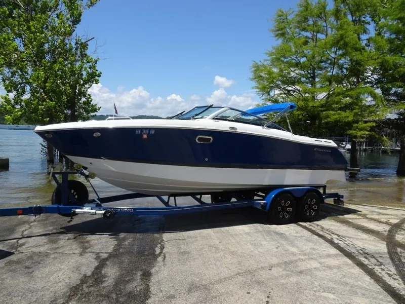 Slide: The Image of 2023 Four Winns H260 boat on trailer by a lake, surrounded by trees. - 4