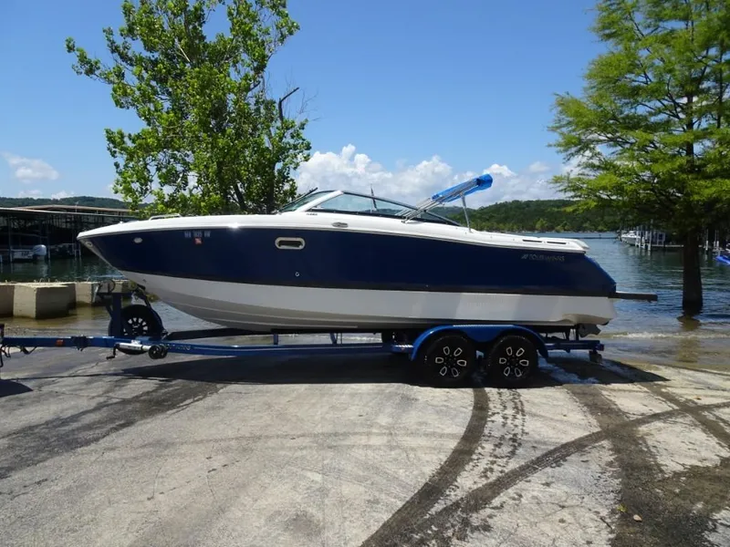 Slide: The Image of 2023 Four Winns H260 boat on trailer by a lake, under clear blue sky. - 5