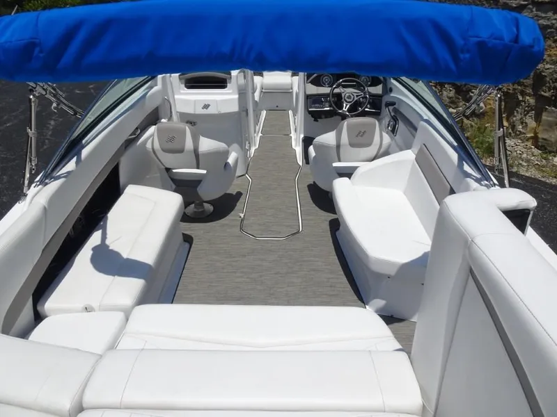 Slide: The Image of 2023 Four Winns H260 boat interior with white seating and blue canopy. - 9